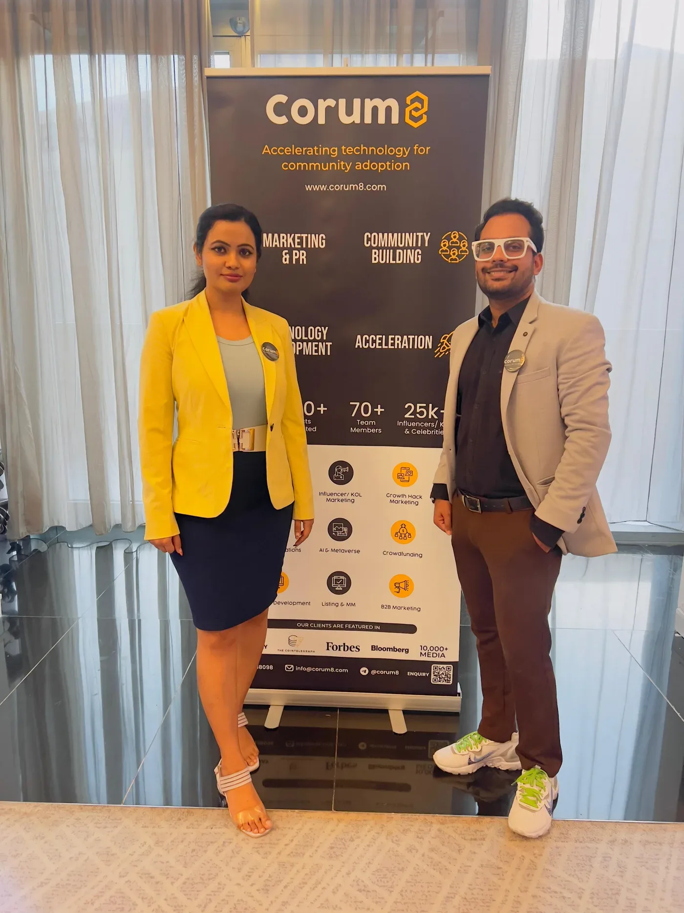 Corum8 team at a branded event banner