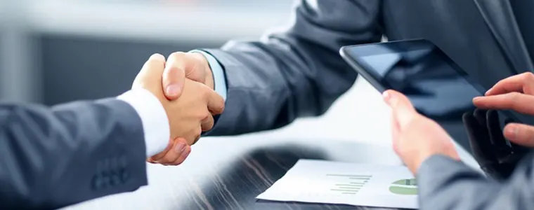 Bankers shaking hands across a desk
