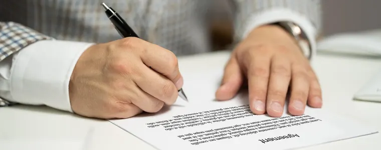 Contract being signed at a desk