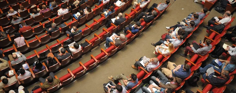 A conference auditorium filled with an audience