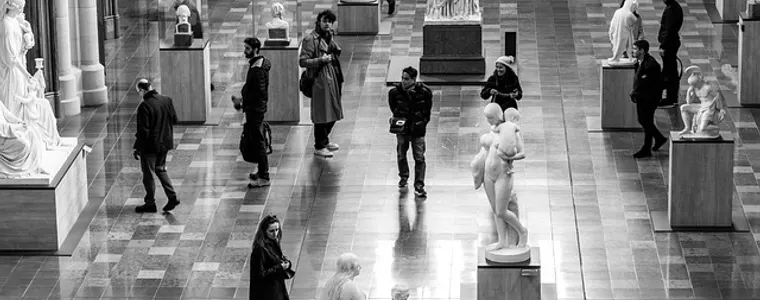 Visitors walking a sculpture gallery